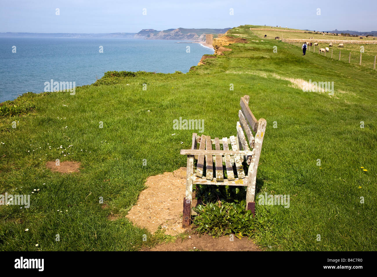 An empty wooden bench seat overlooking the sea near Burton Bradstock village in the spring time, Dorset, Great Britain UK 2008 Stock Photo