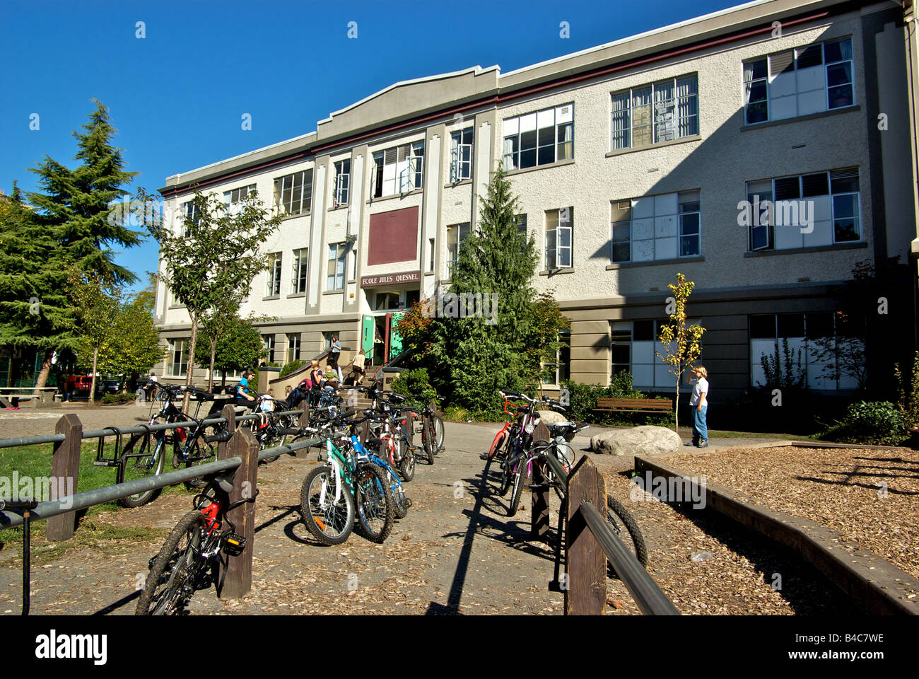 Parents and children waiting outside Ecole Jules Quesnel French immersion elementary public school in Vancouver BC Stock Photo