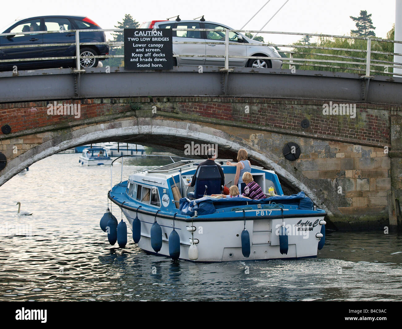 PLEASURE CRUISER GOING UNDER ROAD BRIDGE AT WROXHAM NORFOLK ENGLAND UK Stock Photo