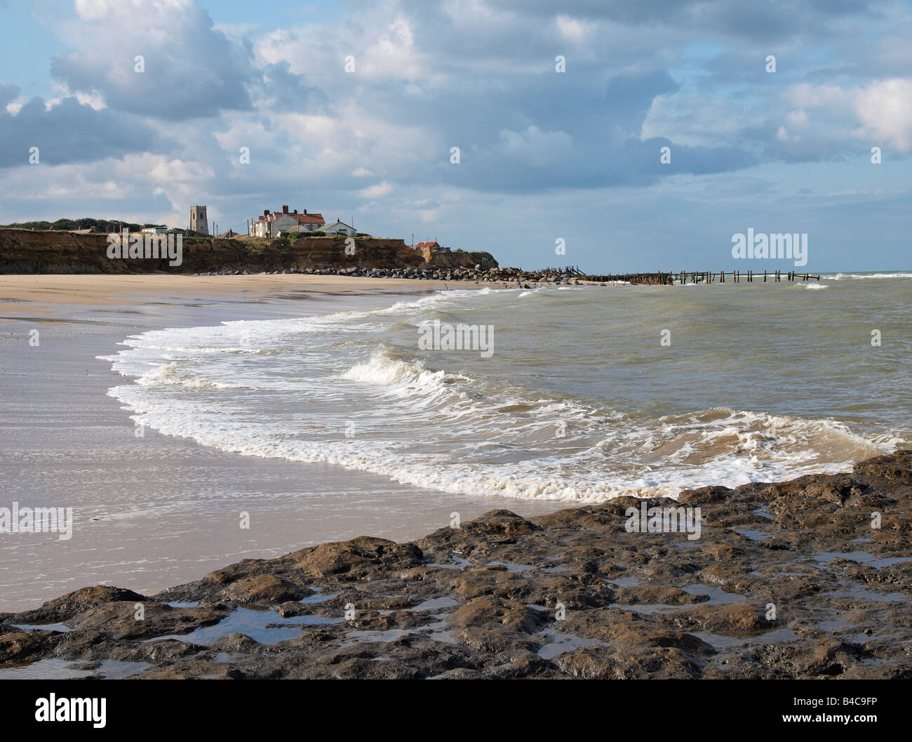 SLOPING SANDY BEACH  AT LOW TIDE,  HAPPISBURGH NORFOLK ENGLAND REVEALING SOFT MUD OR CLAY BASE WHEN SAND IS REMOVED BY STRONG TIDAL ACTION. Stock Photo