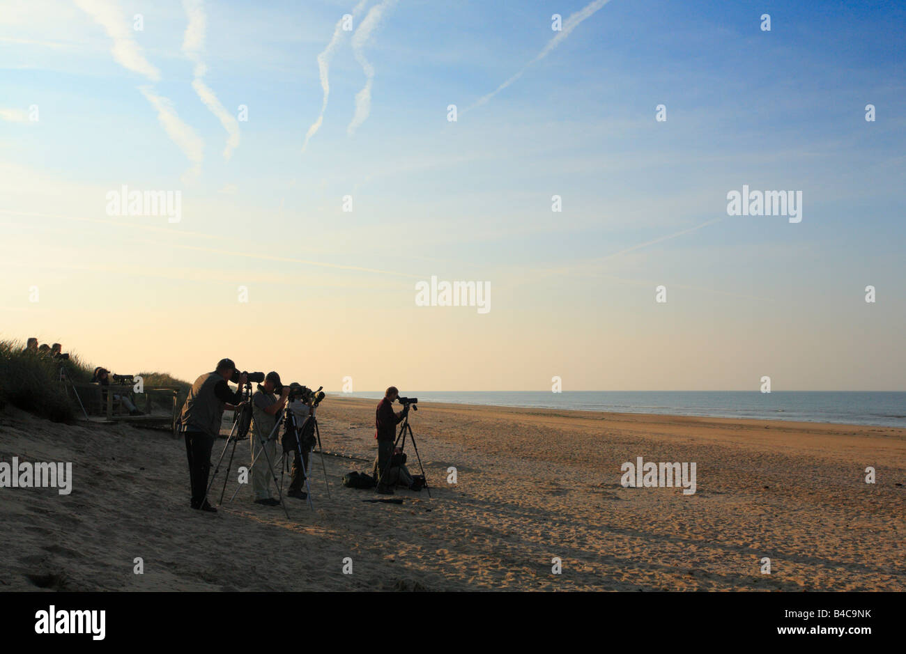 Birdwatchers on the shore at Titchwell Marsh nature reserve on the Norfolk coast. Stock Photo