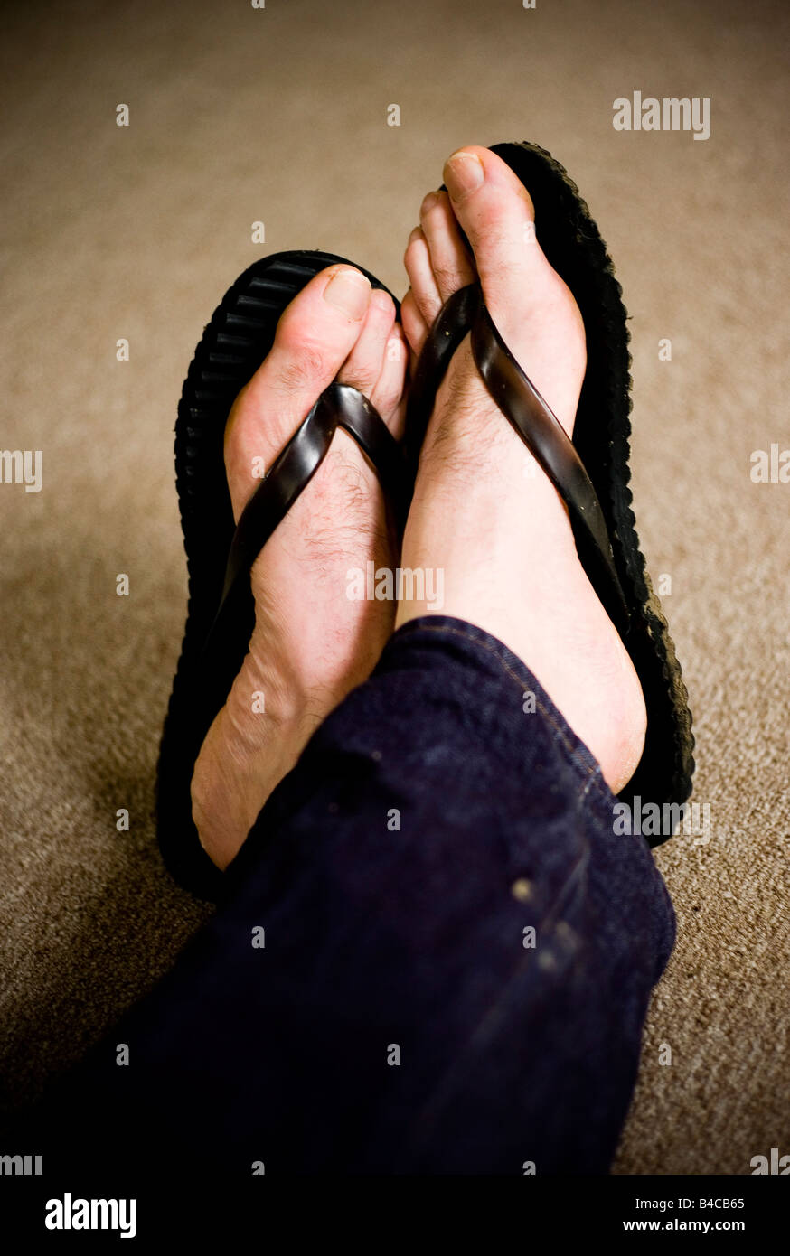 a pair of men s feet in plastic flip flops Stock Photo Alamy