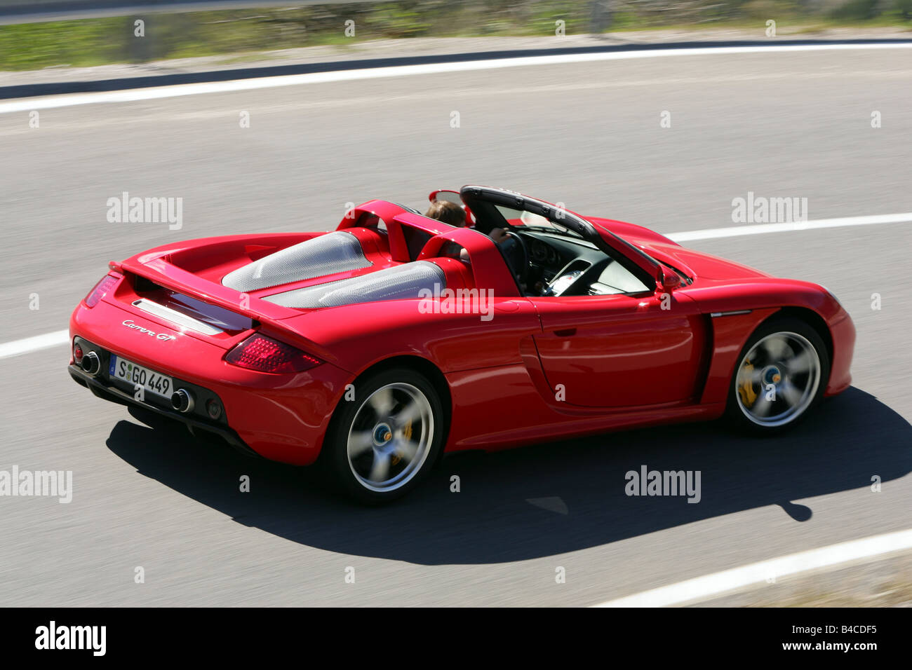 Car, Porsche Carrera GT, model year 2005-, red, Convertible, open top,  driving, diagonal from the back, side view, country road Stock Photo - Alamy
