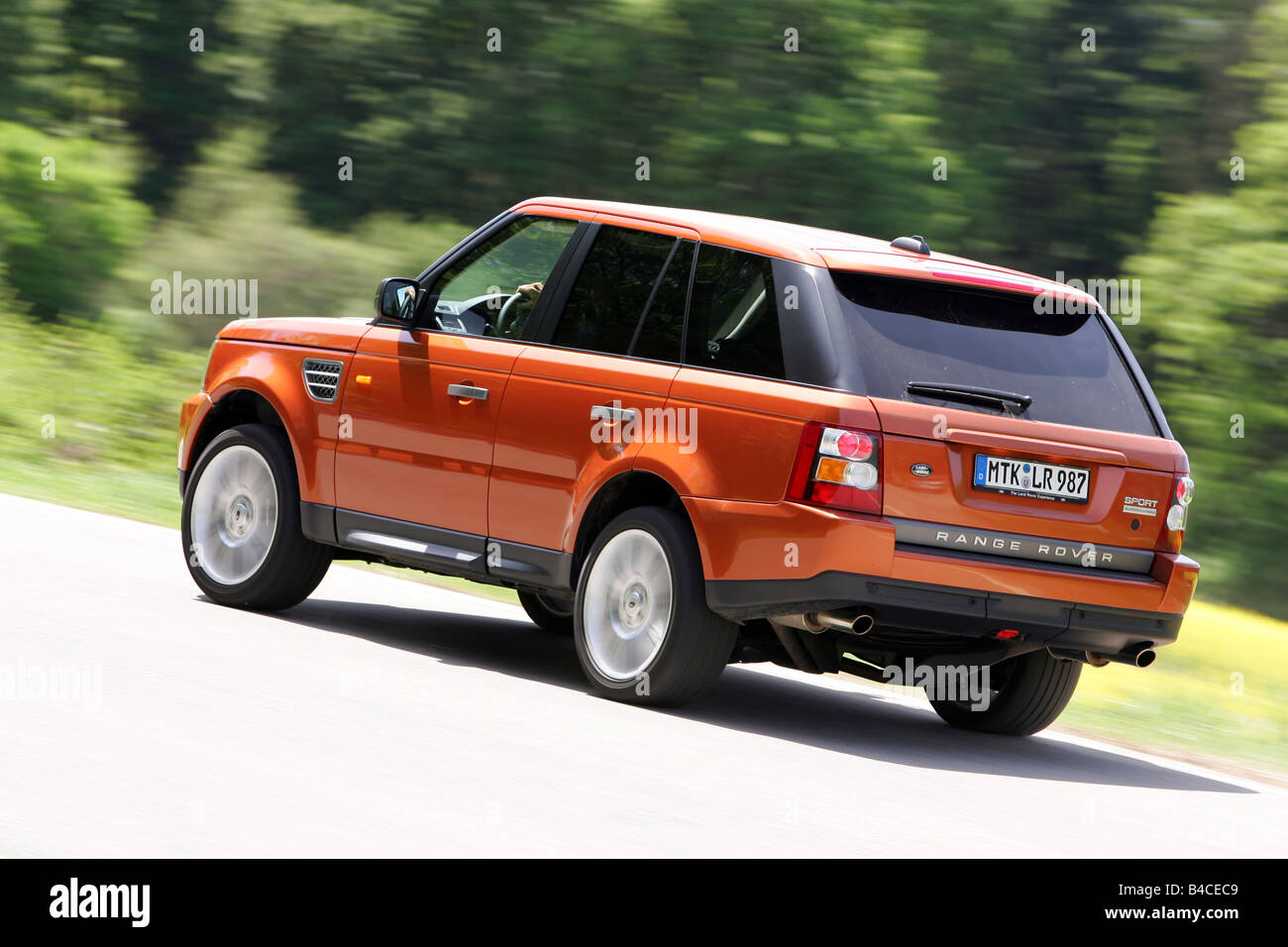 Car, Range Rover Sport V8 Supercharged, model year 2005-, orange , driving, diagonal from the back, rear view, side view, countr Stock Photo