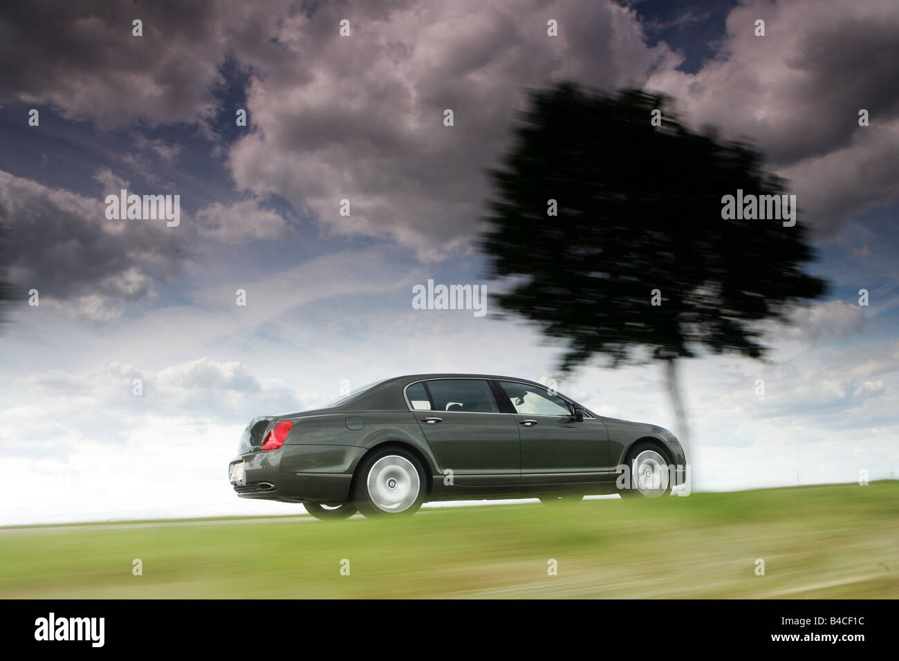 Car, Bentley Continental Flying Spur, anthracite, model year 2005-, driving, diagonal from the back, side view, country road, ve Stock Photo