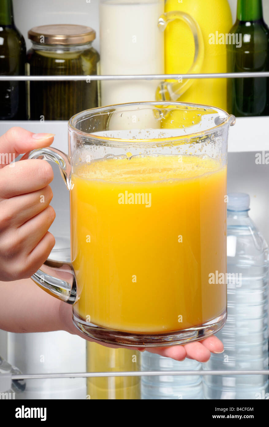 PUTTING JUG OF ORANGE JUICE IN FRIDGE Stock Photo Alamy