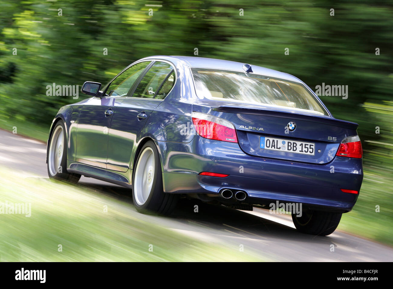 BMW Alpina B5, model year 2005-, dunkelblue moving, diagonal from the back, rear view, country road Stock Photo