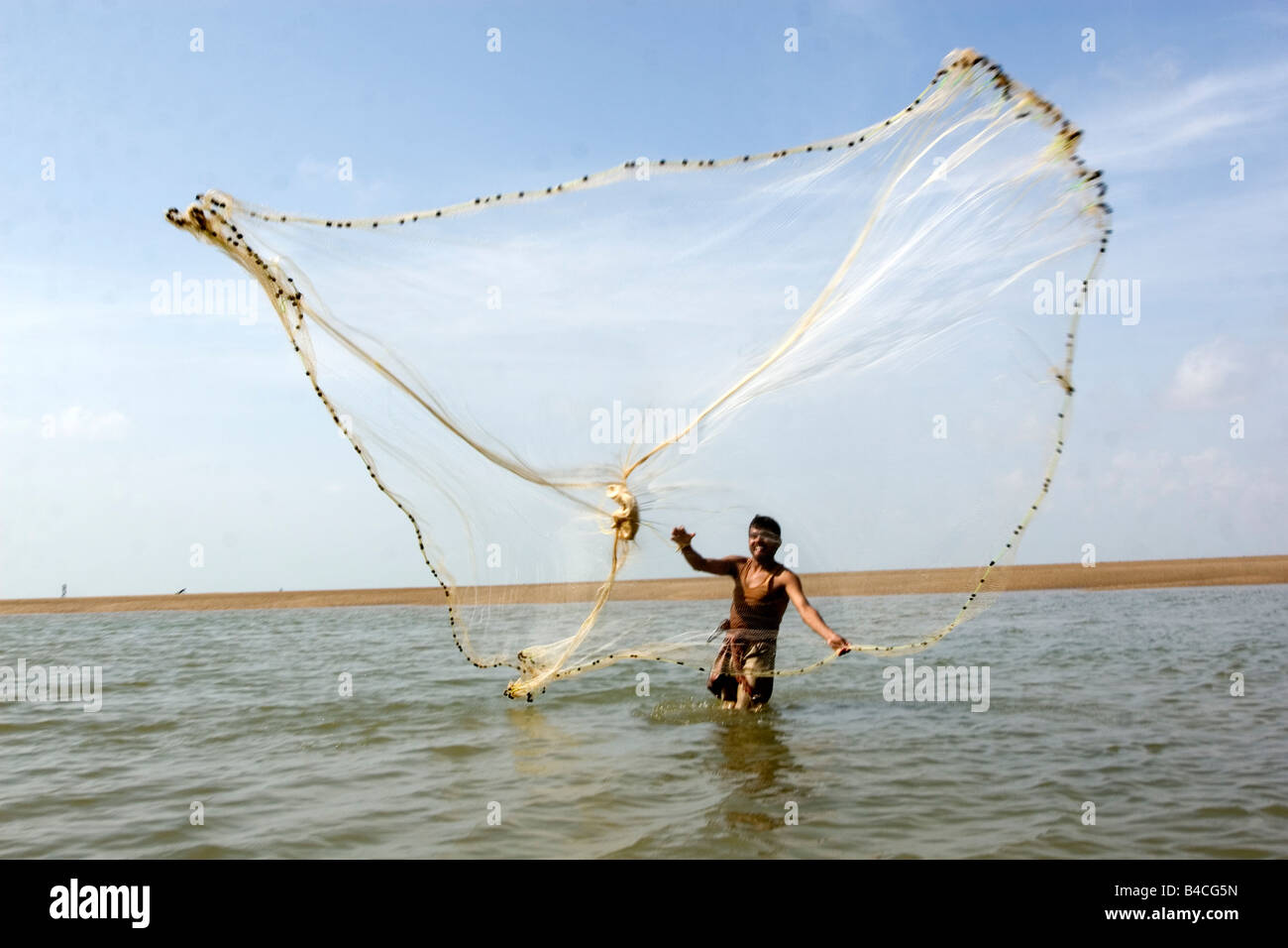 A fisherman spreads fishing net to capture fishes Stock Photo Alamy
