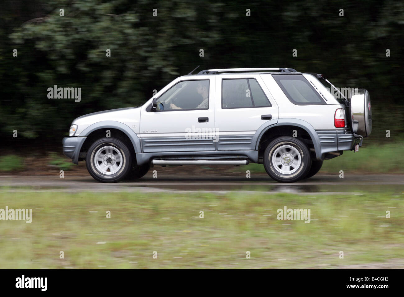 Car, Land breeze, cross country vehicle, model year 2005-, silver, driving, side view, country road Stock Photo