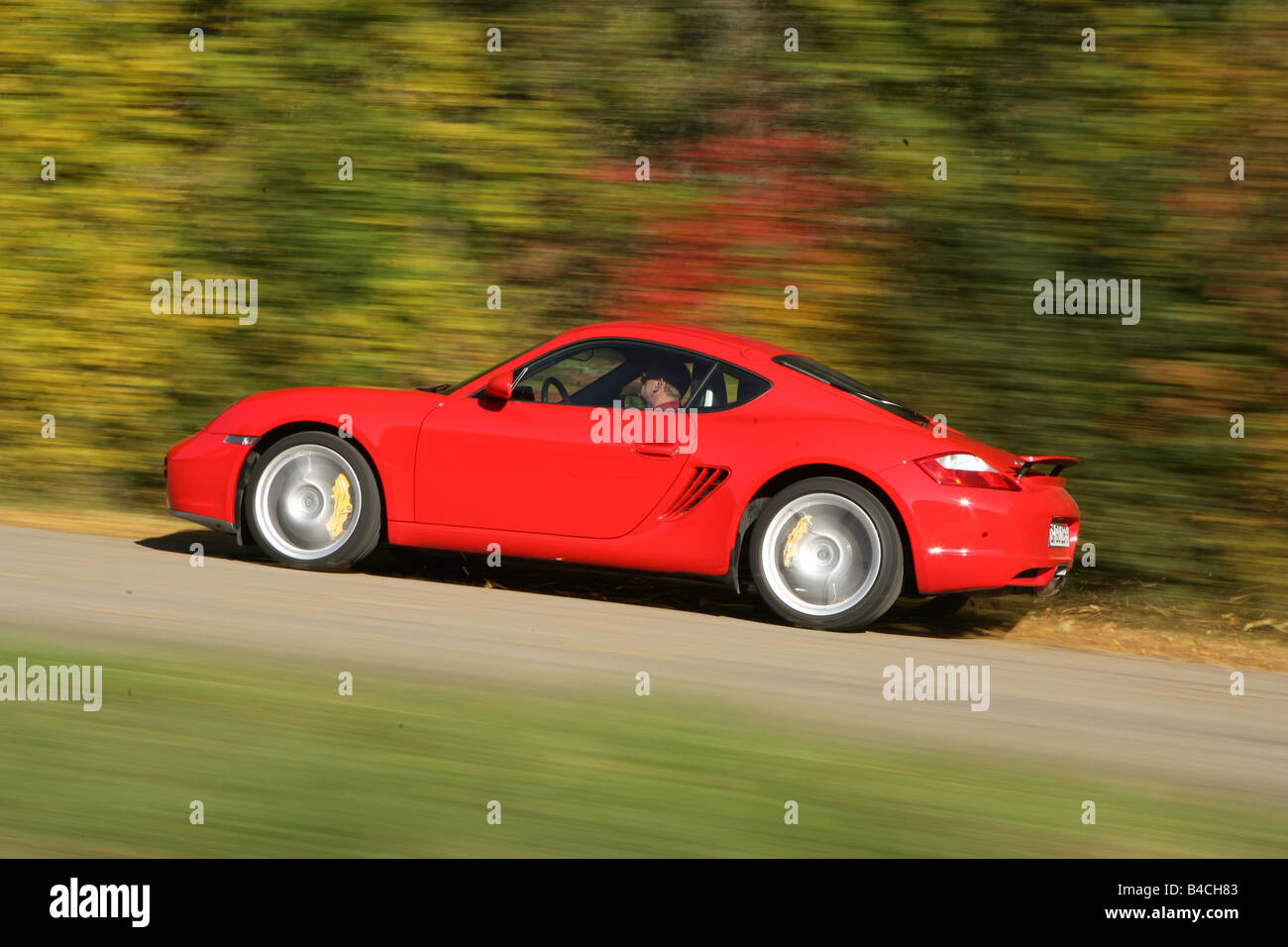 Porsche Cayman S, roadster, model year 2005-, red, driving, side view, country road, landsapprox.e, Autumn Stock Photo