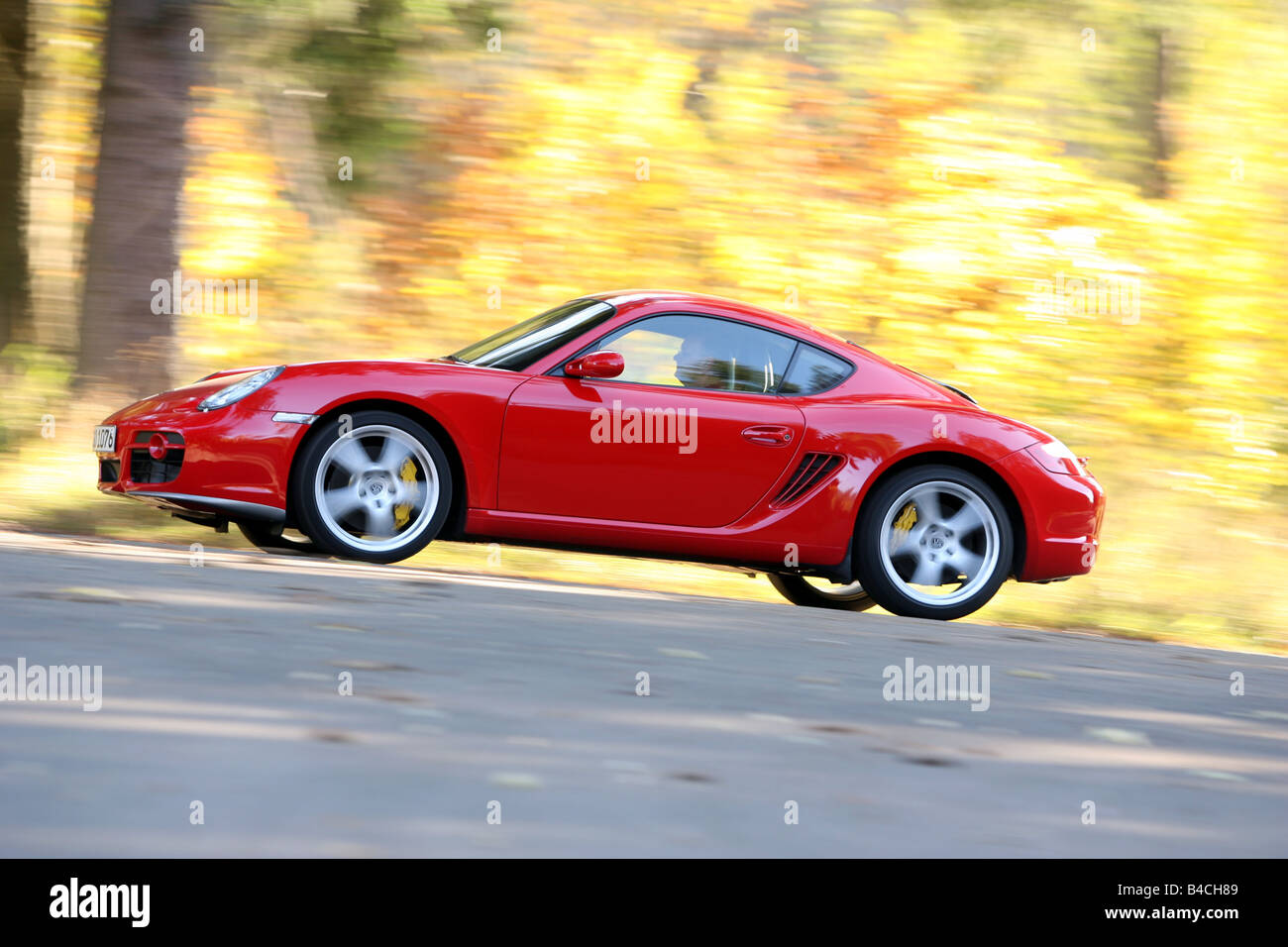 Porsche Cayman S, roadster, model year 2005-, red, driving, side view, country road, landsapprox.e, Autumn Stock Photo