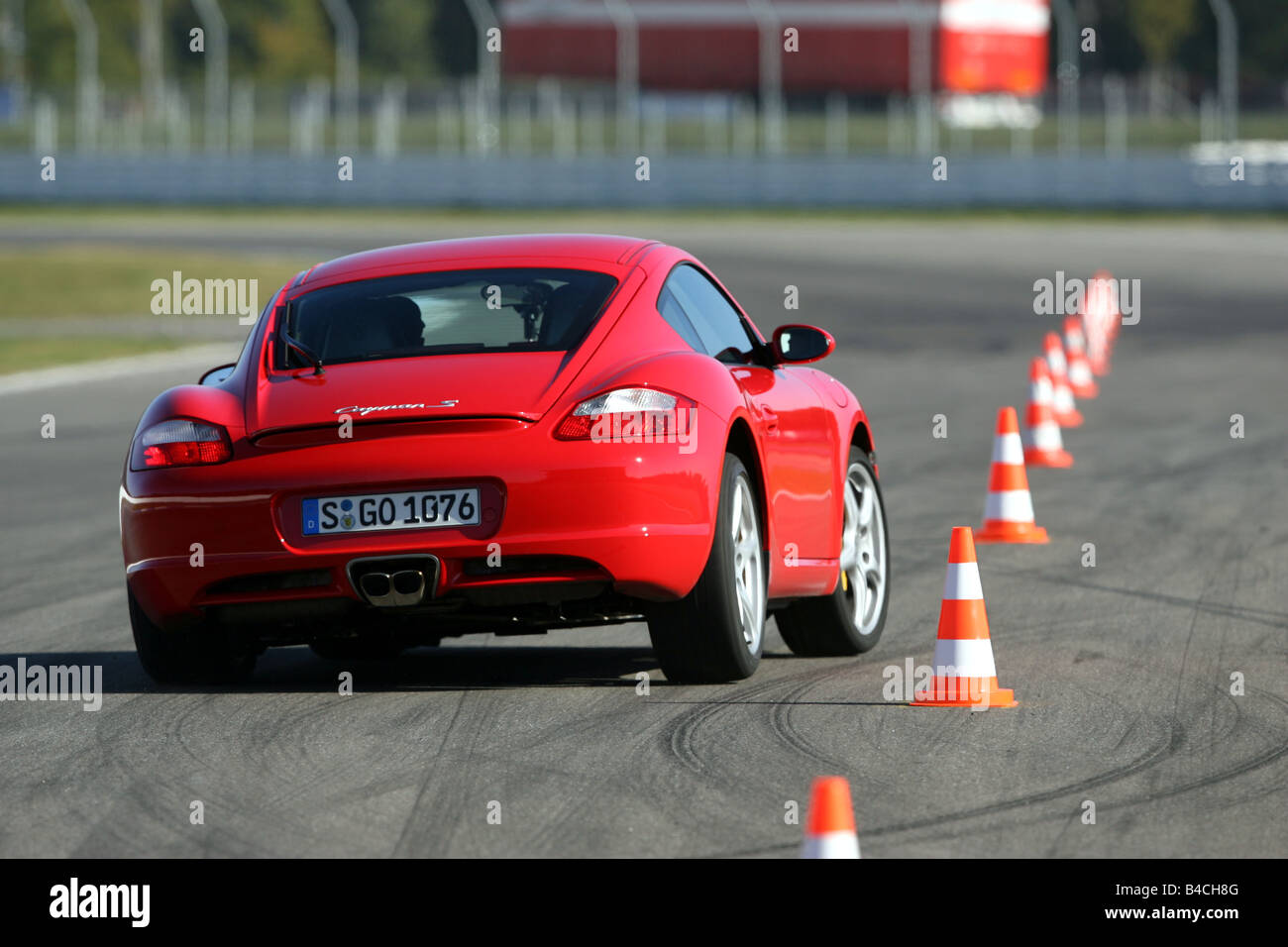 Porsche Cayman S, roadster, model year 2005-, red, driving, diagonal from the back, rear view, test track, Pilonen Stock Photo