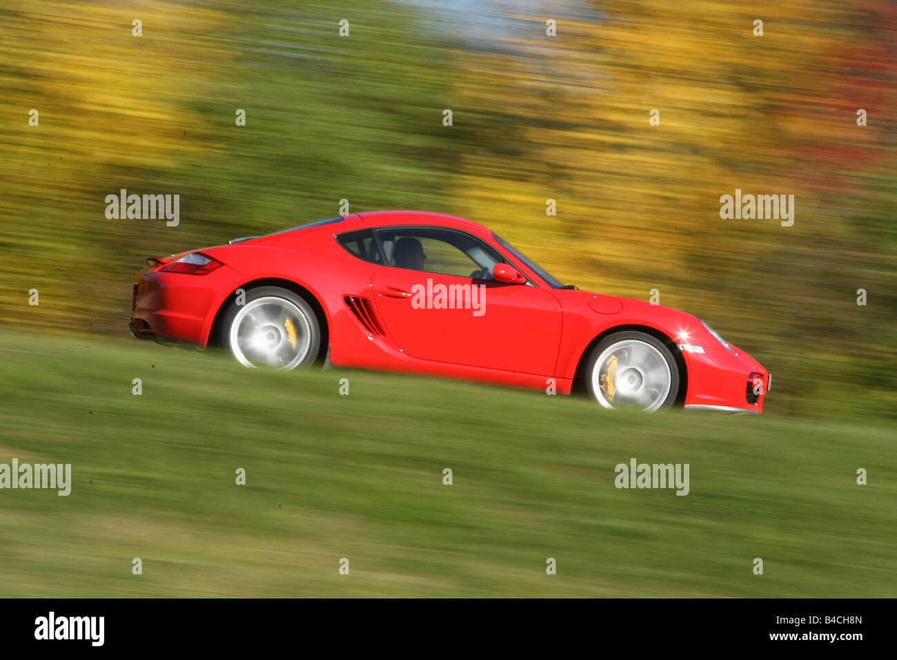 Porsche Cayman S, roadster, model year 2005-, red, driving, side view, country road, landsapprox.e, Autumn Stock Photo