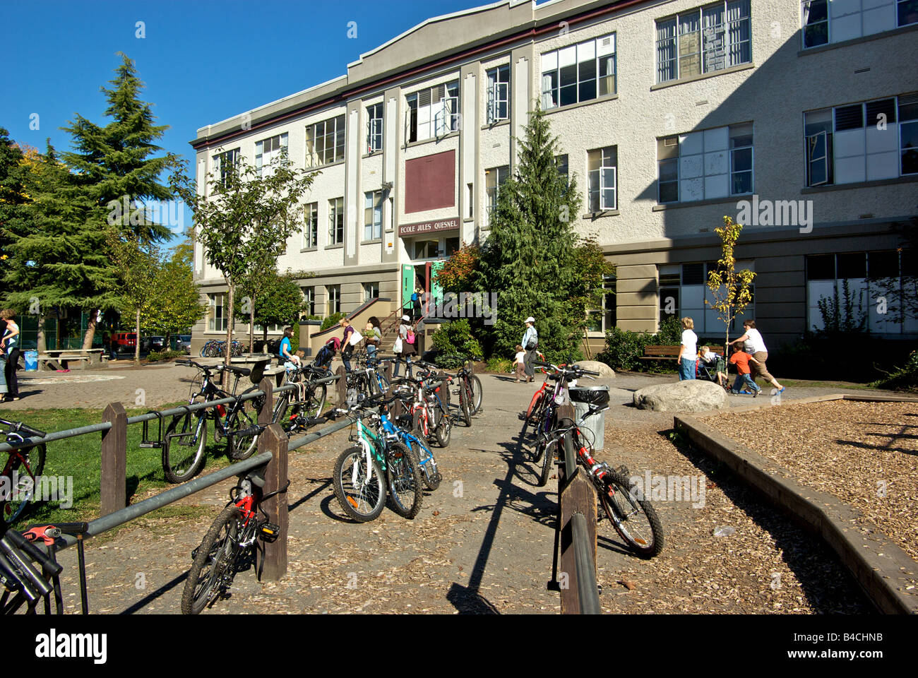 Parents and children waiting outside Ecole Jules Quesnel French immersion elementary public school Vancouver BC Stock Photo