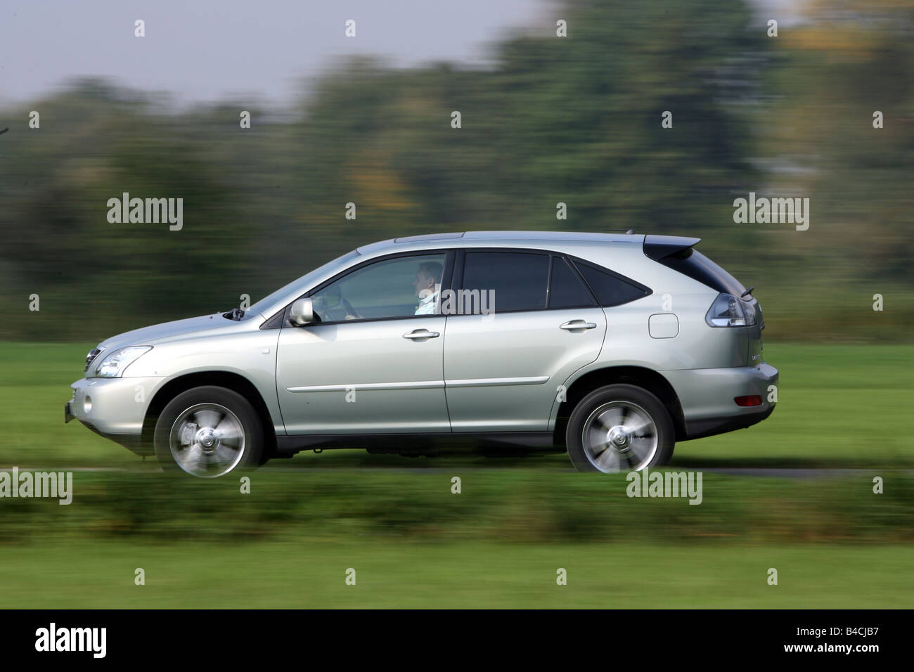 Lexus RX 400h, model year 2005-, silver, driving, side view, country road Stock Photo