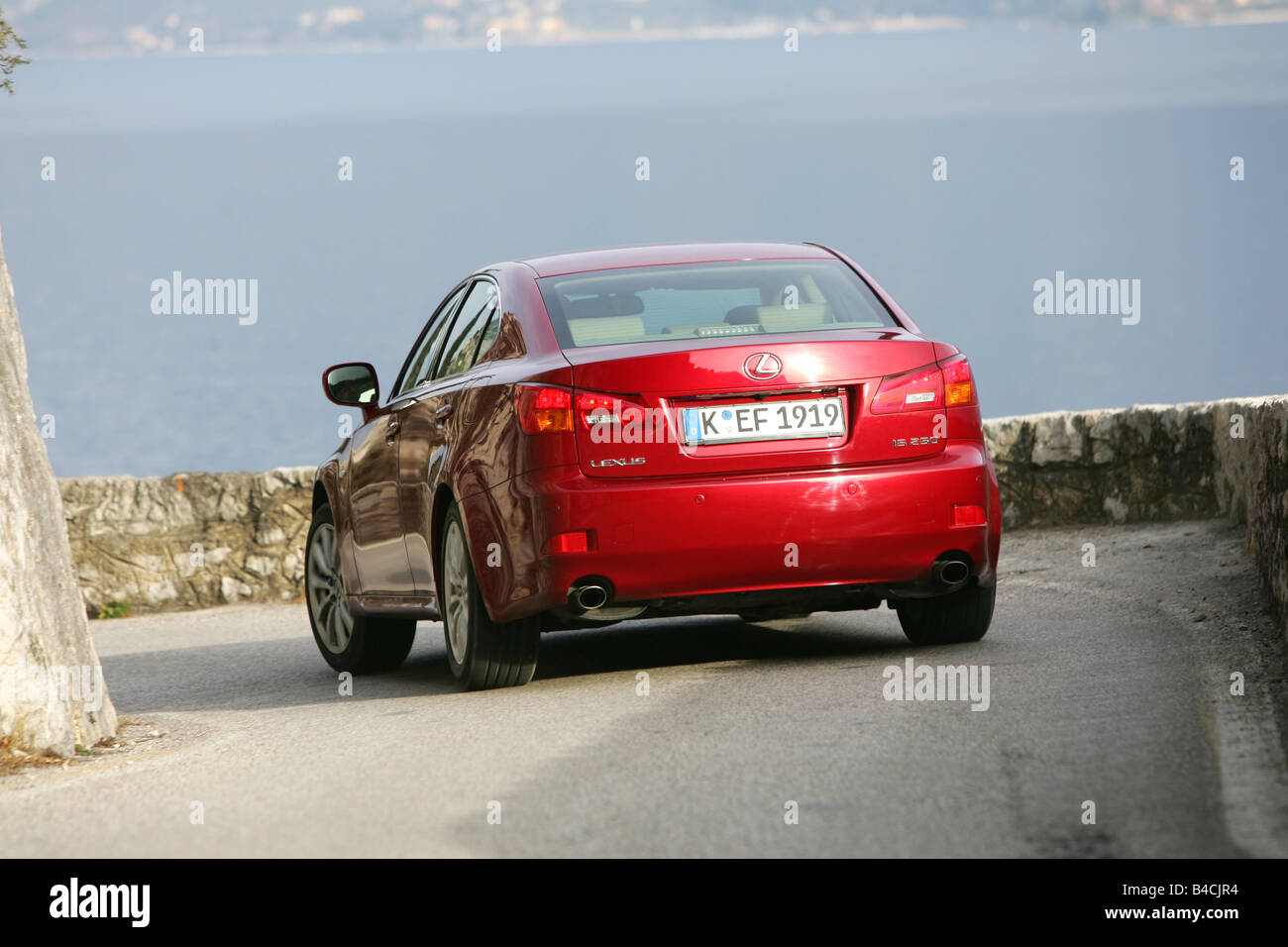Lexus IS 250, model year 2005-, red, driving, diagonal from the back, rear view, country road, lake, Mountains Stock Photo