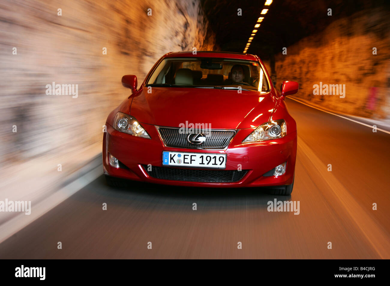 Lexus IS 250, model year 2005-, red, driving, diagonal from the front, frontal view, country road, Mountains, Tunnel Stock Photo