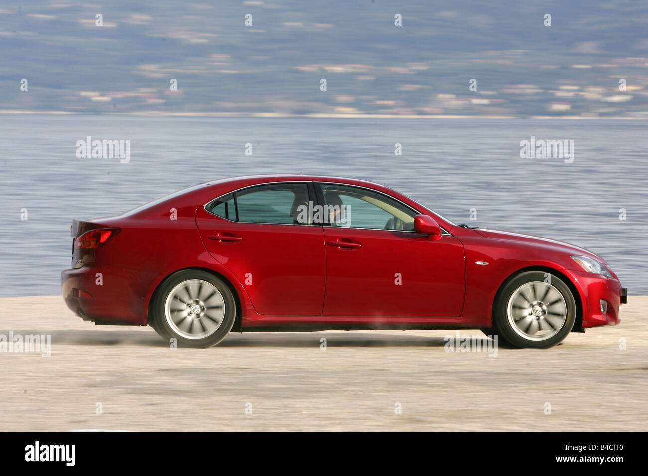 Lexus IS 250, model year 2005-, red, driving, side view, lake Stock Photo
