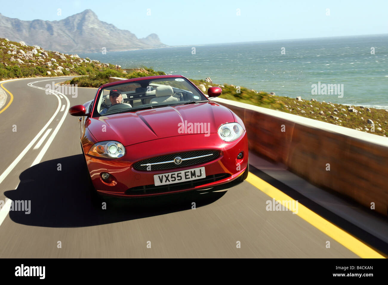 Jaguar XK 4.2 V8 Convertible, model year 2006-, red, driving, diagonal from the front, frontal view, country road, landsapprox.e Stock Photo