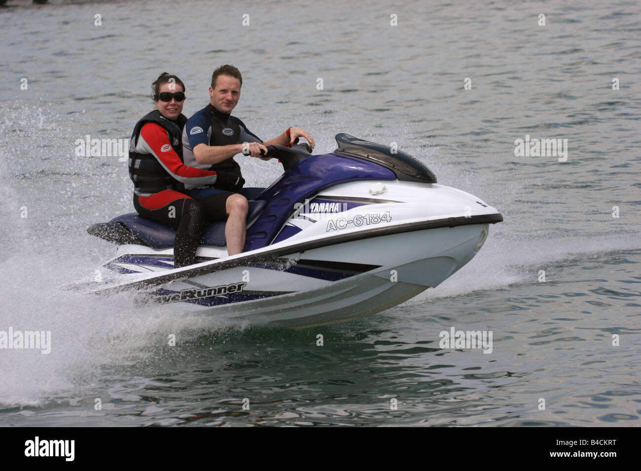 Couple cruising on a jet ski. facing. horizontal Milford Haven Marina