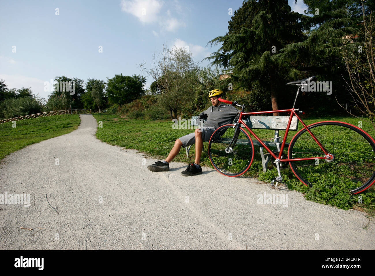 Boy's relaxing on a bench next to his bike. Stock Photo
