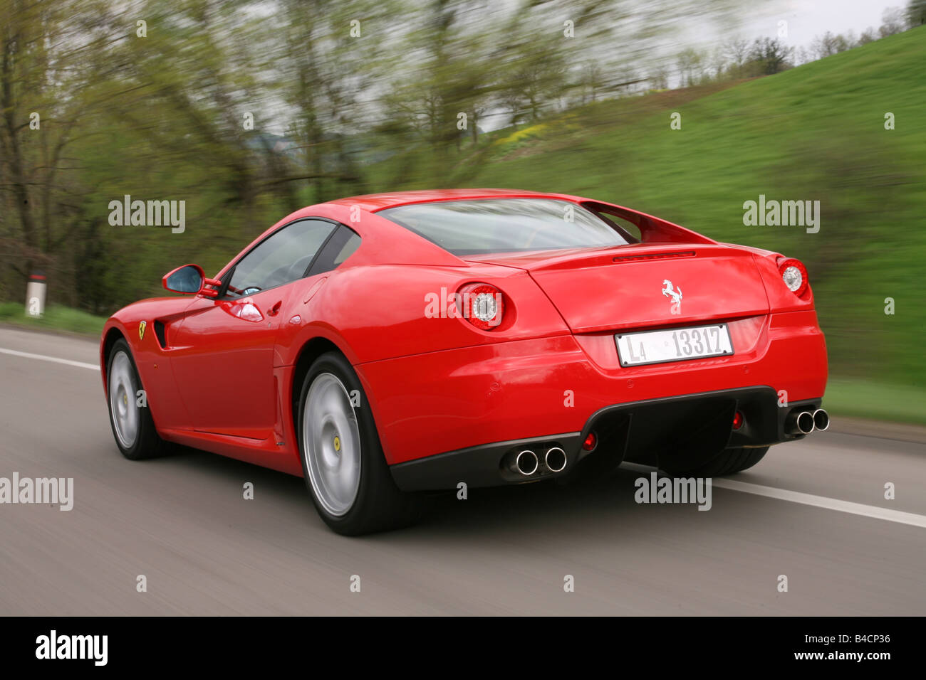 Ferrari 599 GTB, model year 2006-, red, driving, diagonal from the back, rear view, country road Stock Photo