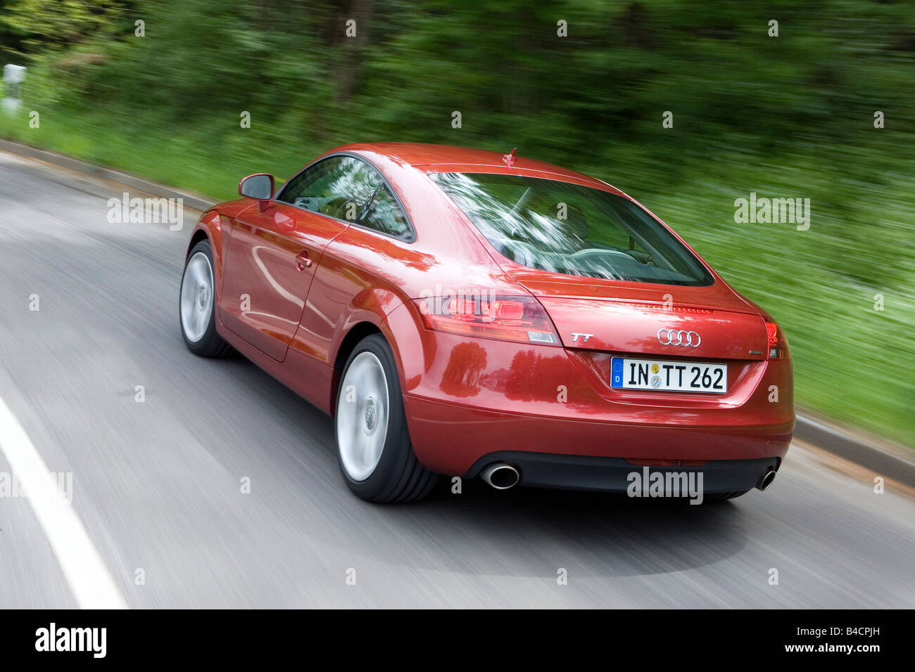 Audi TT 3.2 V6, model year 2006-, red/ruby colored, driving, diagonal from the back, rear view, City, country road Stock Photo