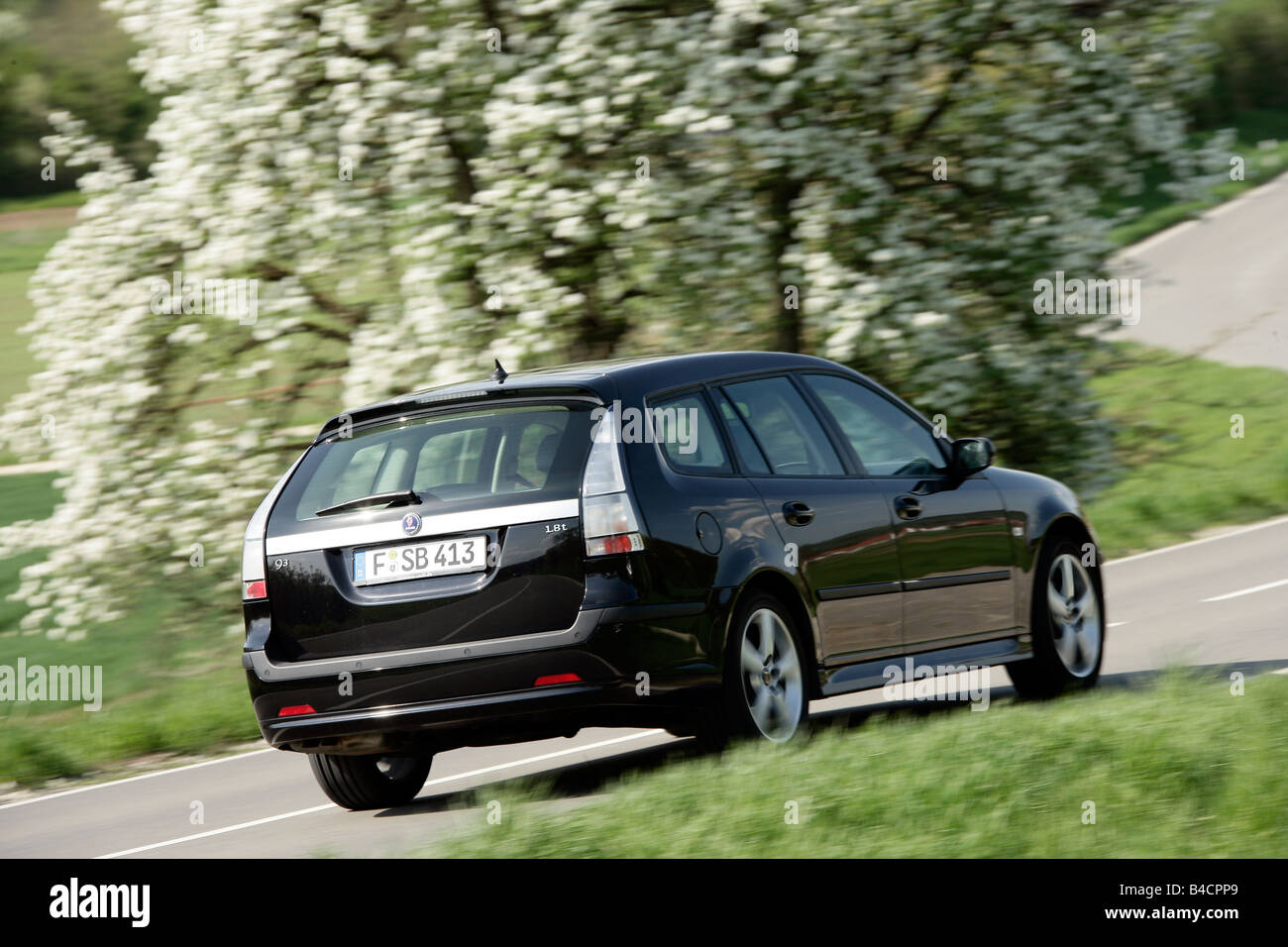 Saab 9-3 1.8t Sport Combi, model year 2006-, black, driving, diagonal from the back, rear view, country road Stock Photo