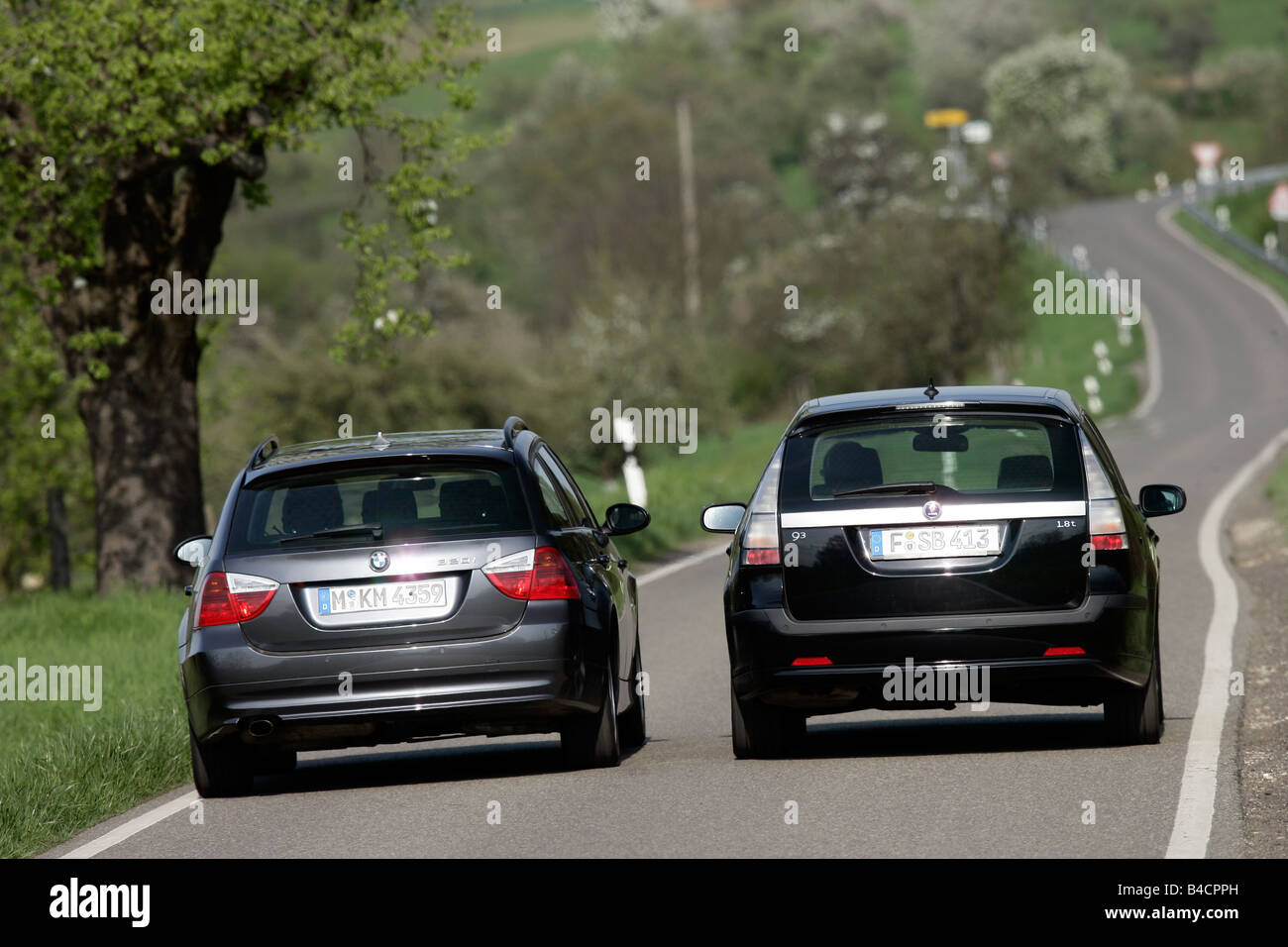 Saab 9-3 1.8t Sport Combi, model year 2006-, and BMW 320 i Touring, black, driving, rear view, country road, Overtaking on the h Stock Photo