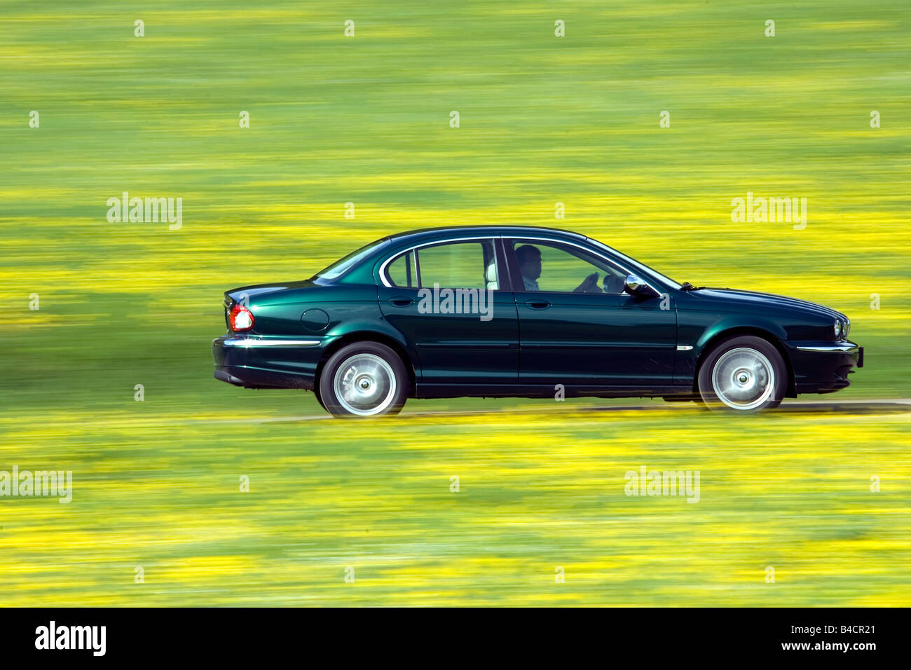 Jaguar X-Type 2.2D, model year 2006-, dark green, driving, side view, country road Stock Photo