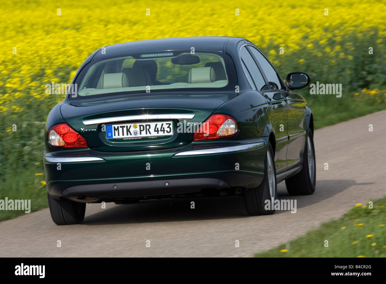 Jaguar X-Type 2.2D, model year 2006-, dark green, driving, diagonal from the back, rear view, country road Stock Photo