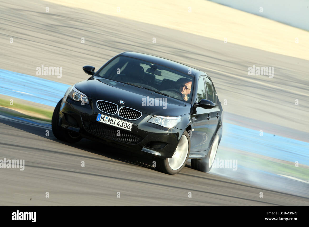 BMW M5, model year 2005-, black, driving, diagonal from the front, frontal  view, test track, Drift, drifting Stock Photo - Alamy