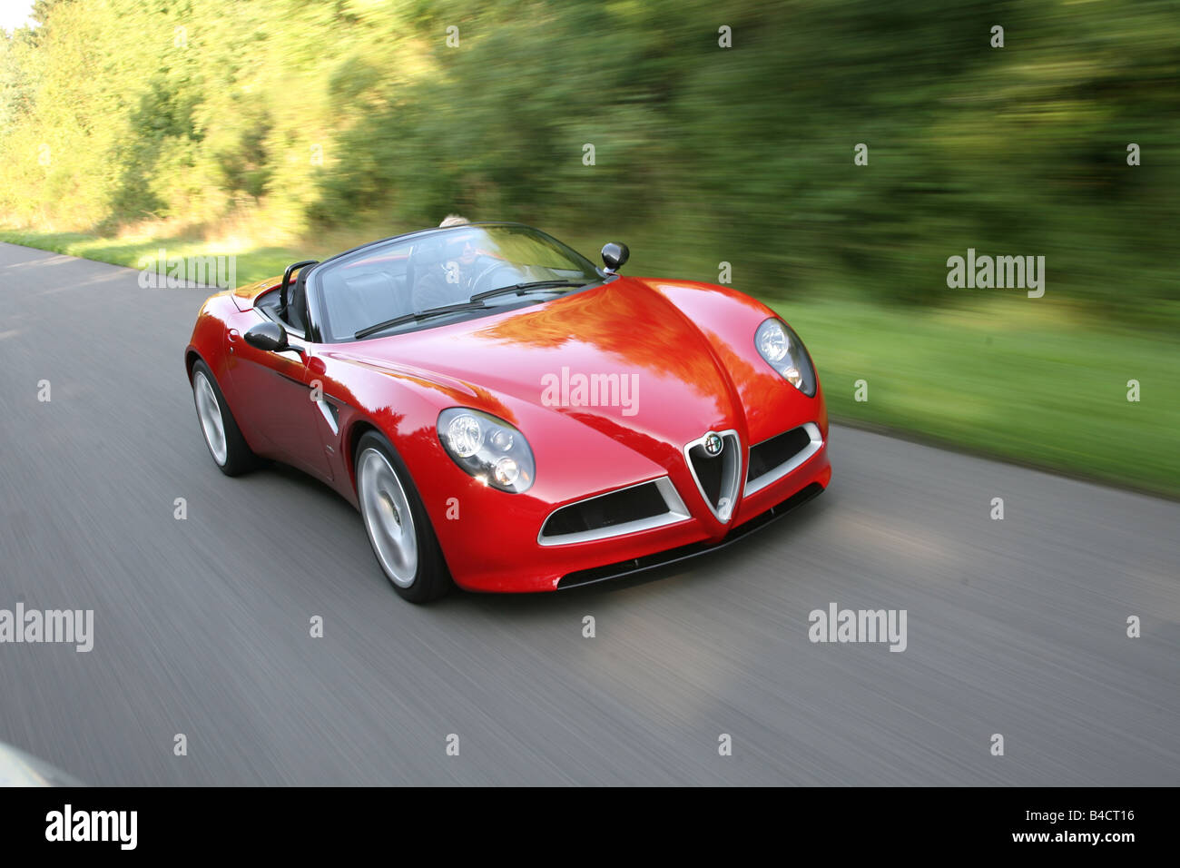 Alfa Romeo 8C Spider, model year 2006-, red, driving, diagonal from the  front, frontal view, country road, landsapprox.e, open t Stock Photo - Alamy