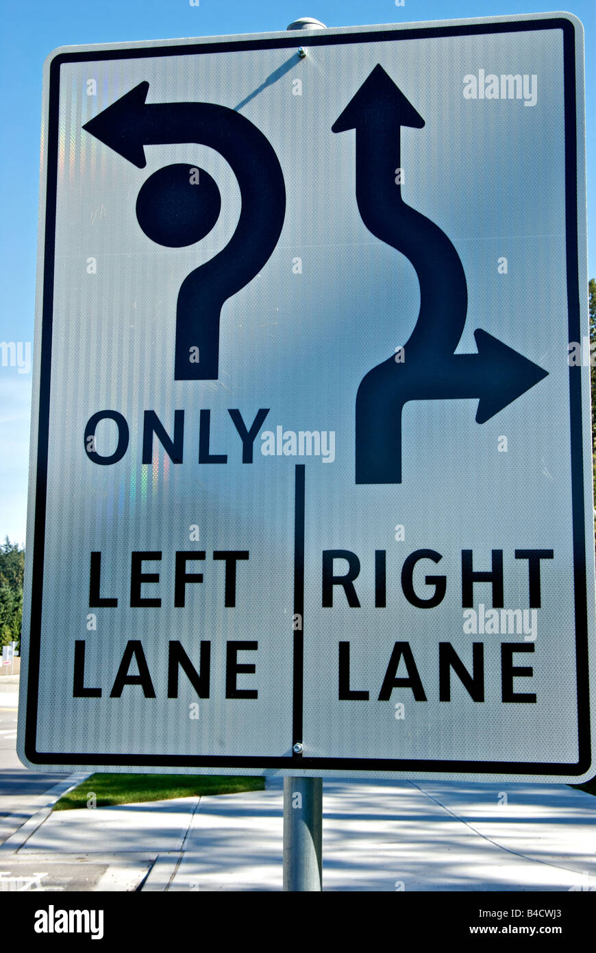 Reflective roundabout traffic lane control sign indicating lane a driver should be in to turn left right or continue through Stock Photo