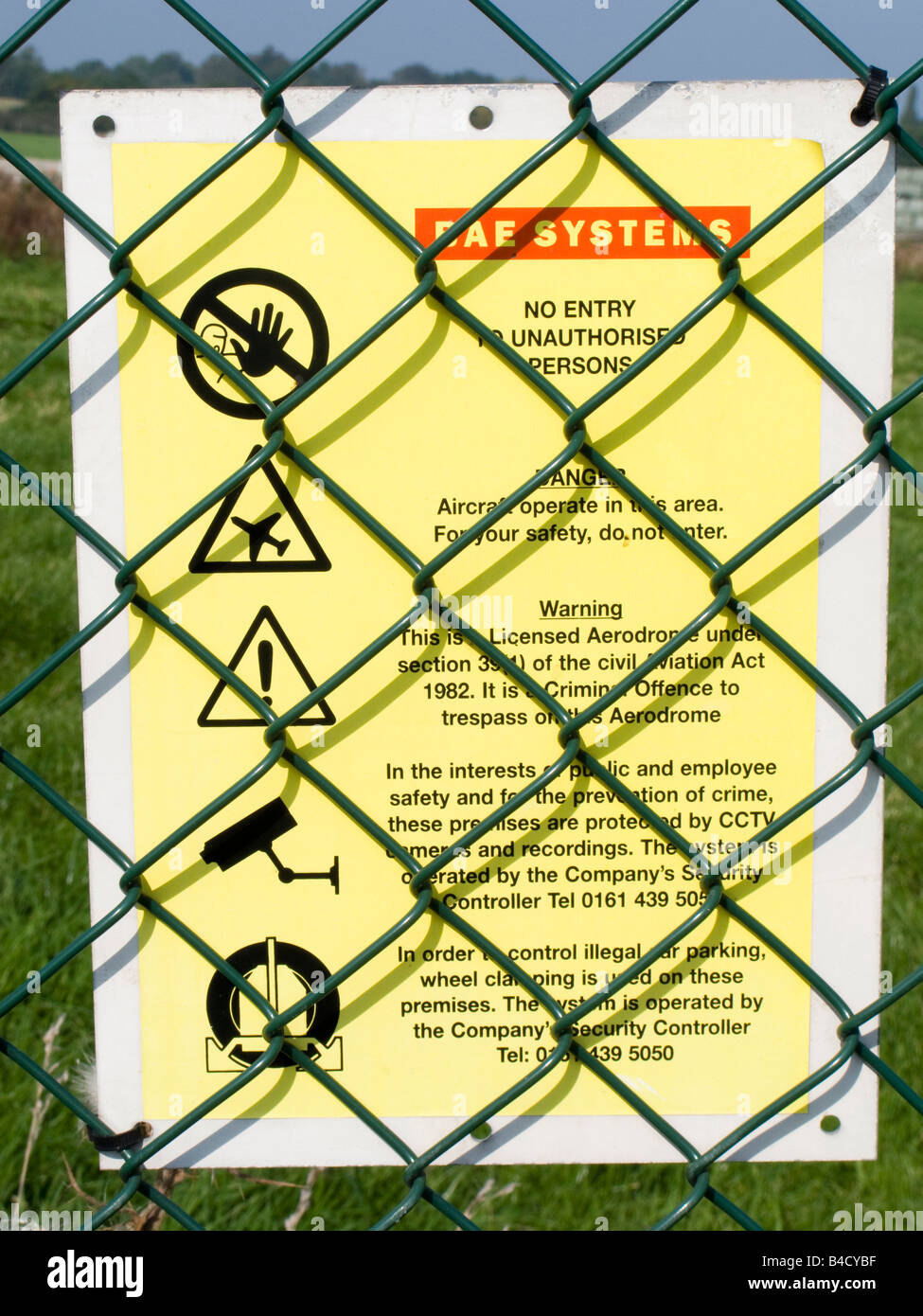 Defence Woodford security warning notice on BAe Systems Airfield perimeter fence Stock Photo