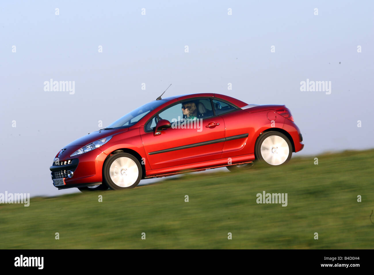 https://c8.alamy.com/comp/B4D0H4/peugeot-207-cc-model-year-2007-red-driving-side-view-country-road-B4D0H4.jpg