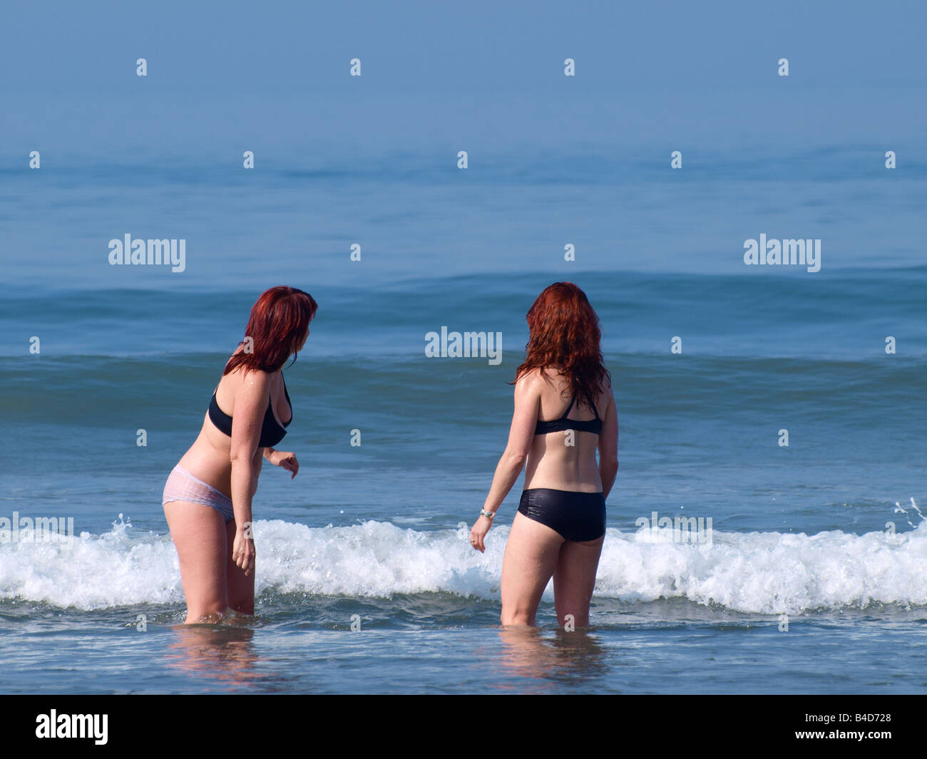 Two young women wading into the sea for a swim in their underwear Stock  Photo - Alamy