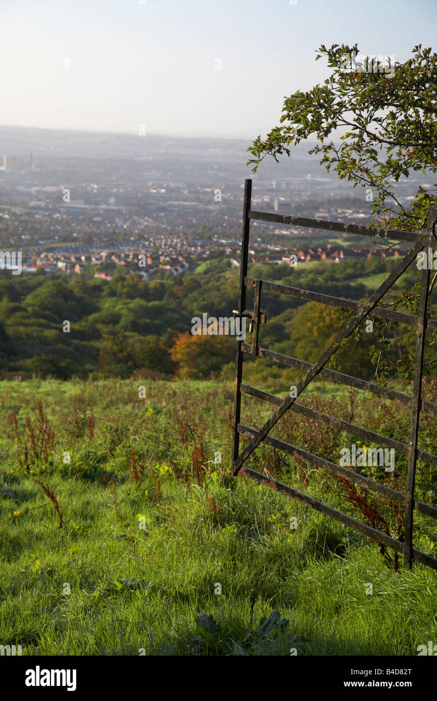 open metal gate to overgrown field overlooking belfast city from the hills belfast northern ireland Stock Photo