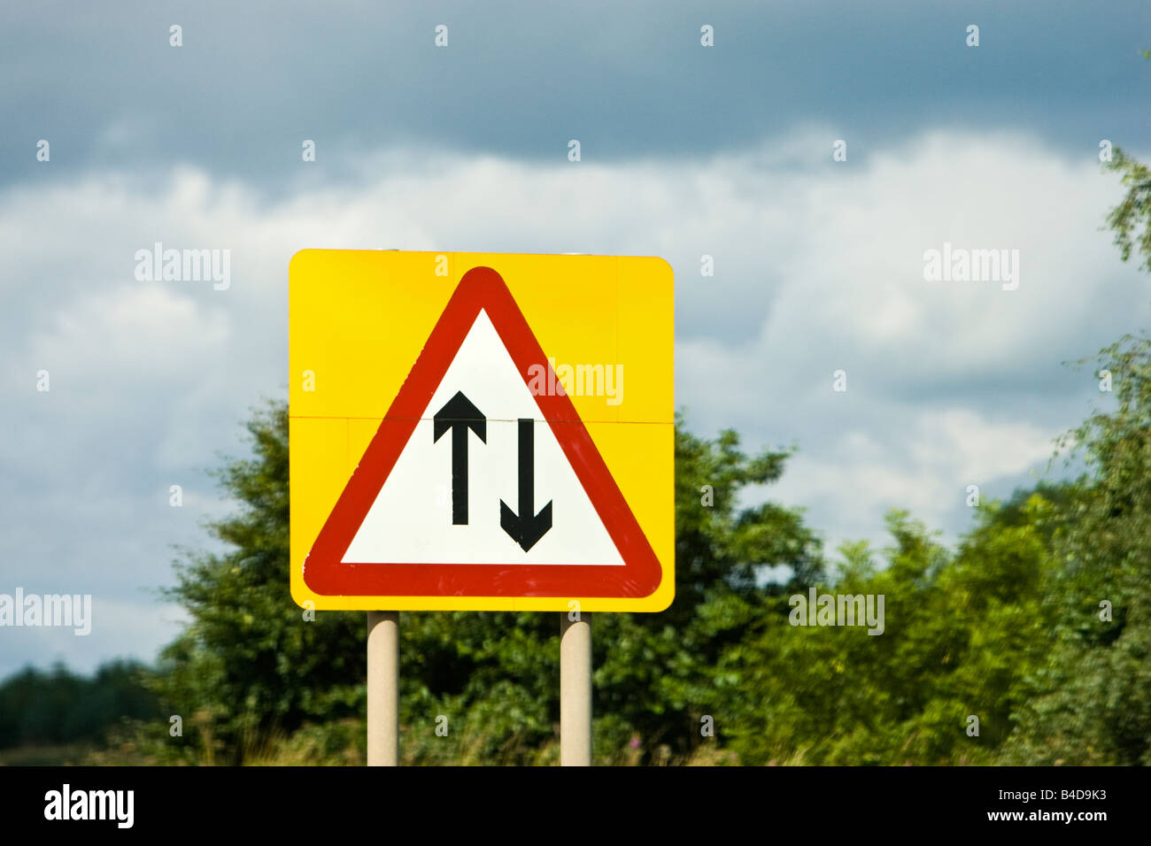 Road sign warning of two way traffic straight ahead England UK Stock Photo