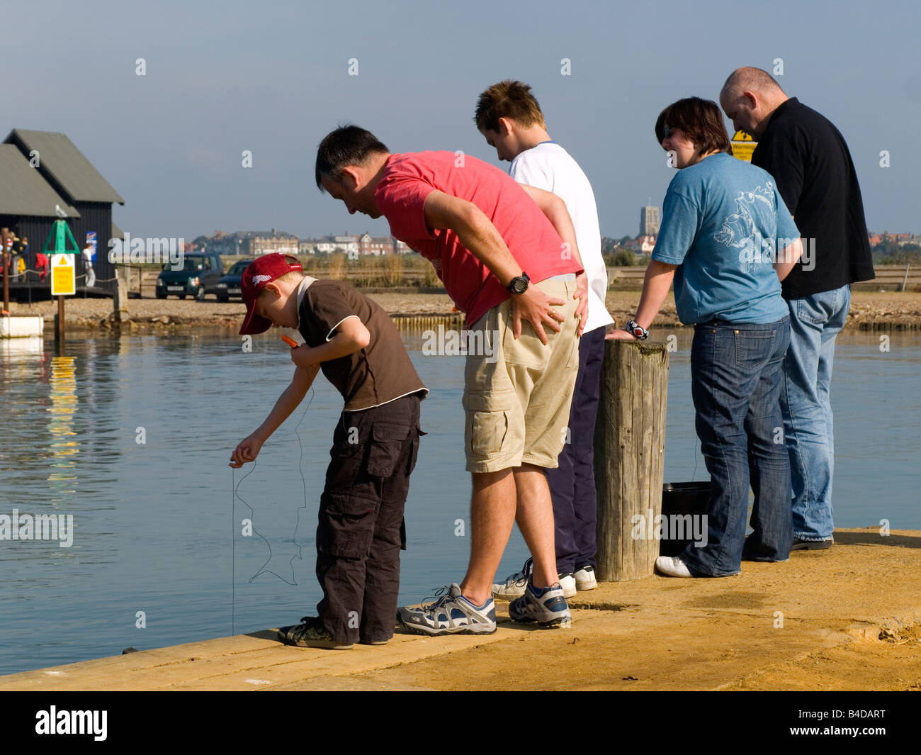 A family fishing for crabs in the river Blyth at Walberswick Suffolk UK Stock Photo