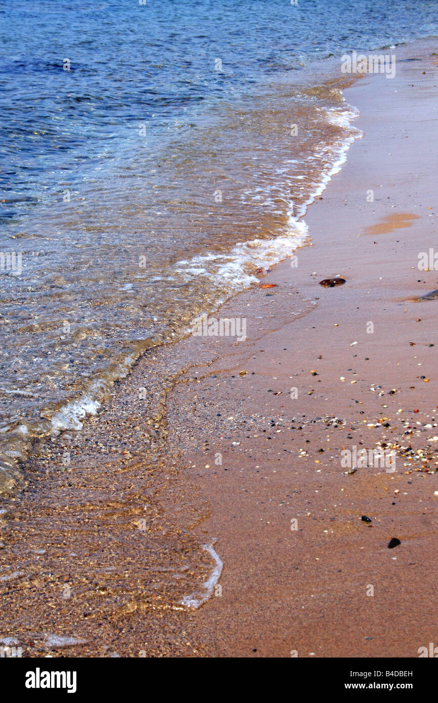 SMALL WAVES LAPPING THE GREEK SHORELINE. Stock Photo