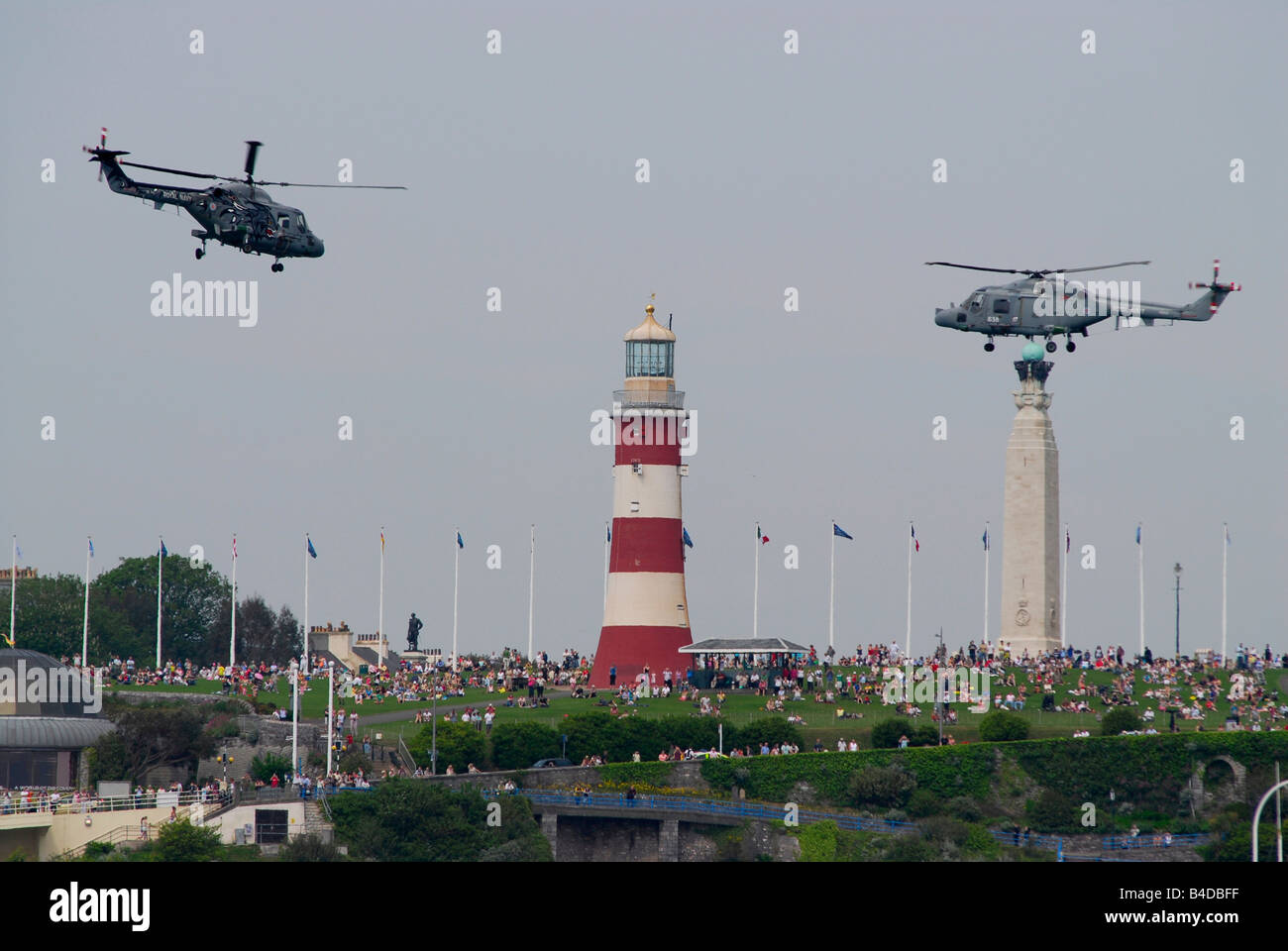 Two Royal Navy helicopters above Smeaton's Tower (lighthouse) on Plymouth Hoe, UK, with crowds of people (2008 Transat Race) Stock Photo