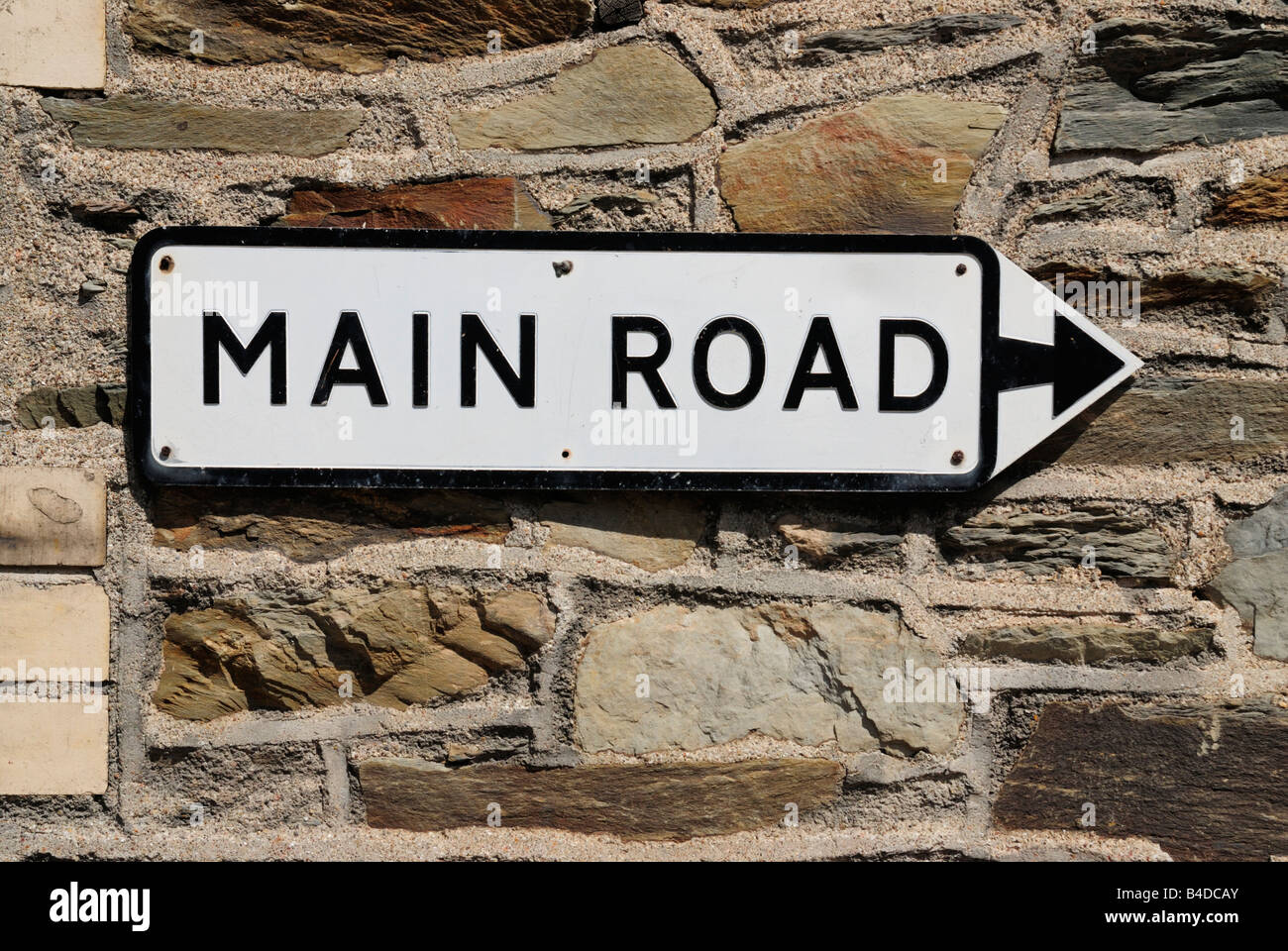 Sign saying Main Road on a stone wall, UK Stock Photo
