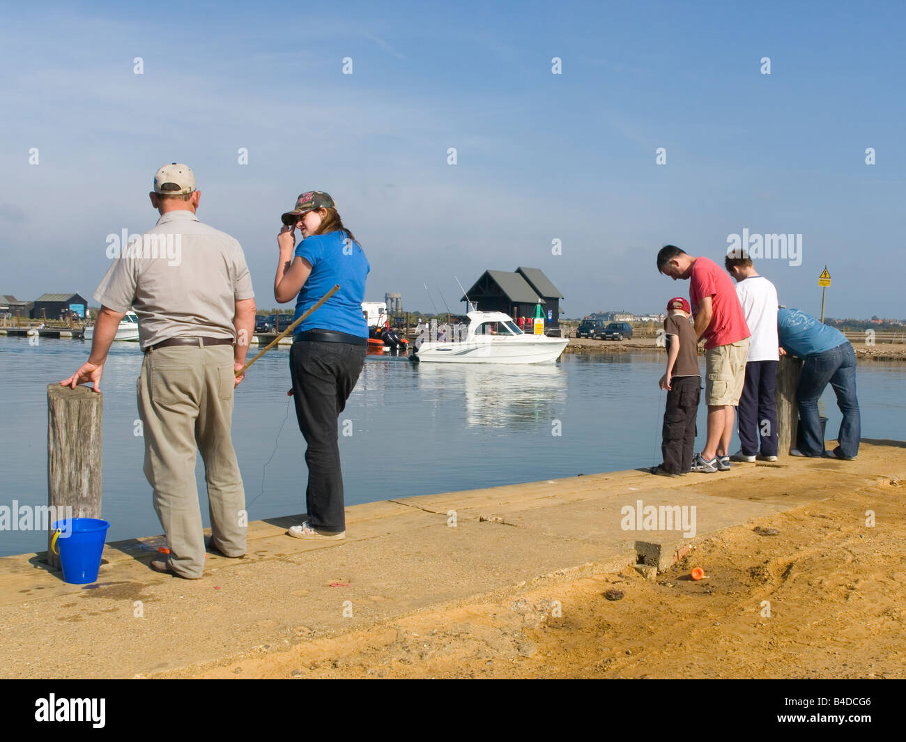 People fishing for crabs in the river Blyth at Walberswick Suffolk UK Stock Photo