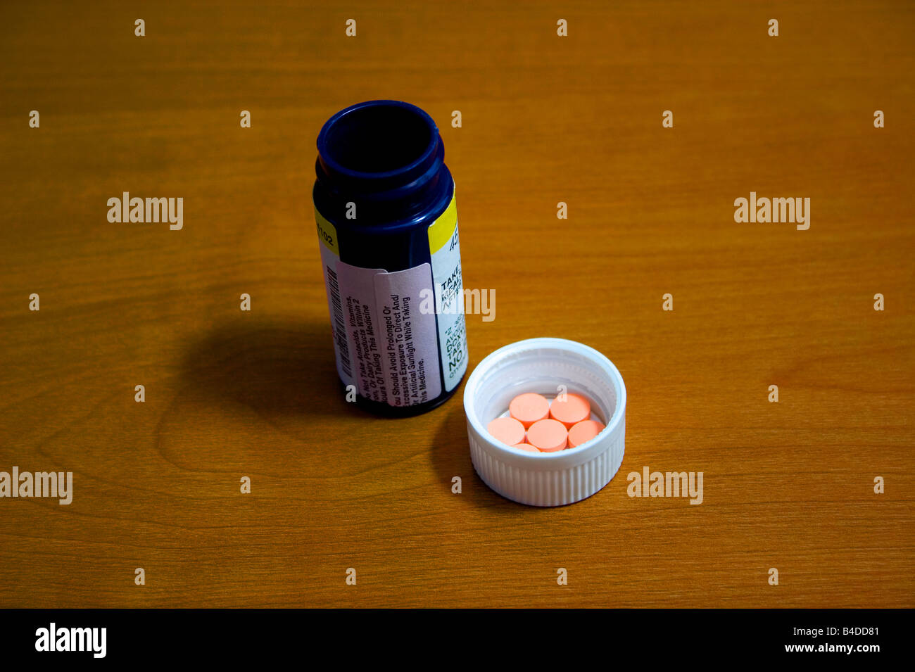 Pills are sitting in the top of a prescription pill bottle Stock Photo