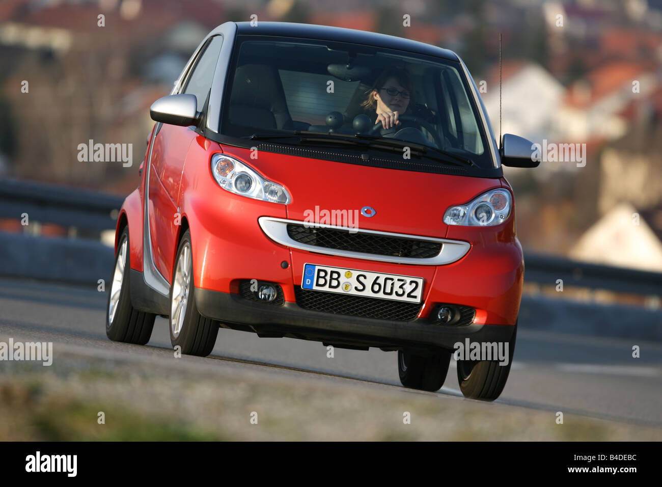 Smart Fortwo Passion, model year 2007-, red, driving, diagonal from the front, frontal view, country road Stock Photo