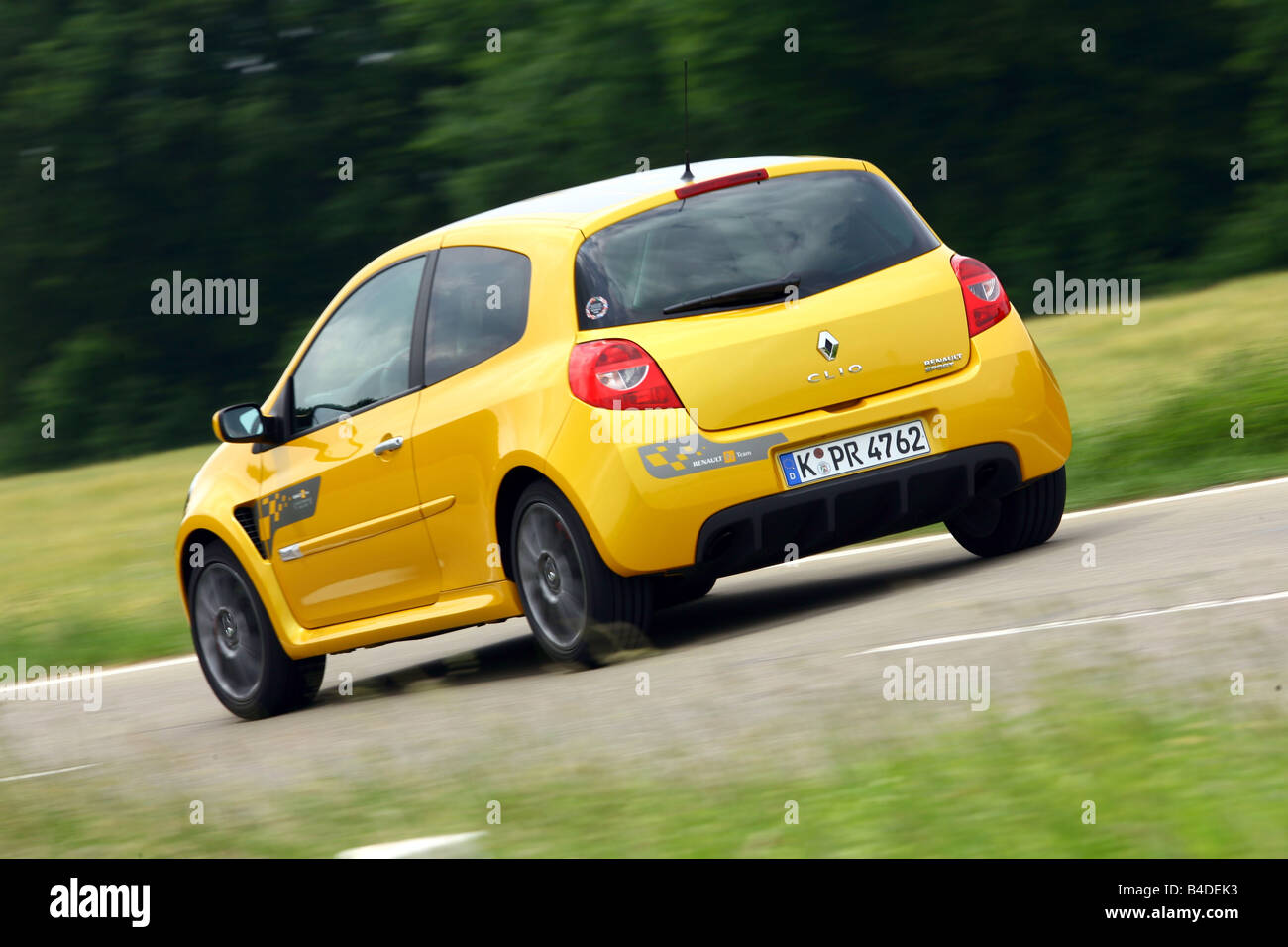 Renault Clio Sport F1-Team, model year 2007-, yellow, driving, diagonal from the back, rear view, country road Stock Photo