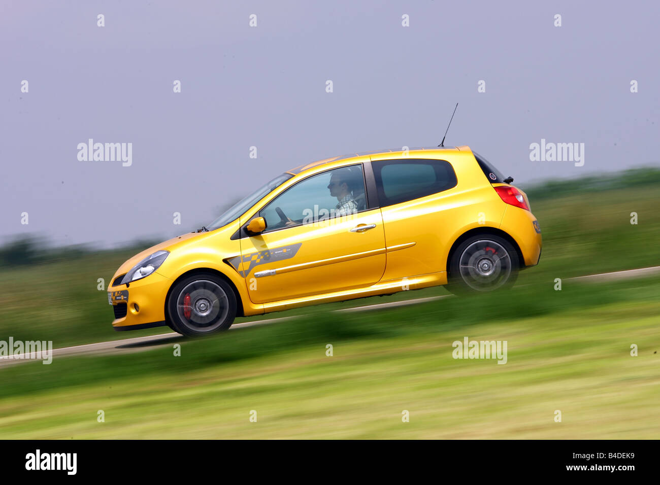 Renault Clio Sport F1-Team, model year 2007-, yellow, driving, side view, country road Stock Photo
