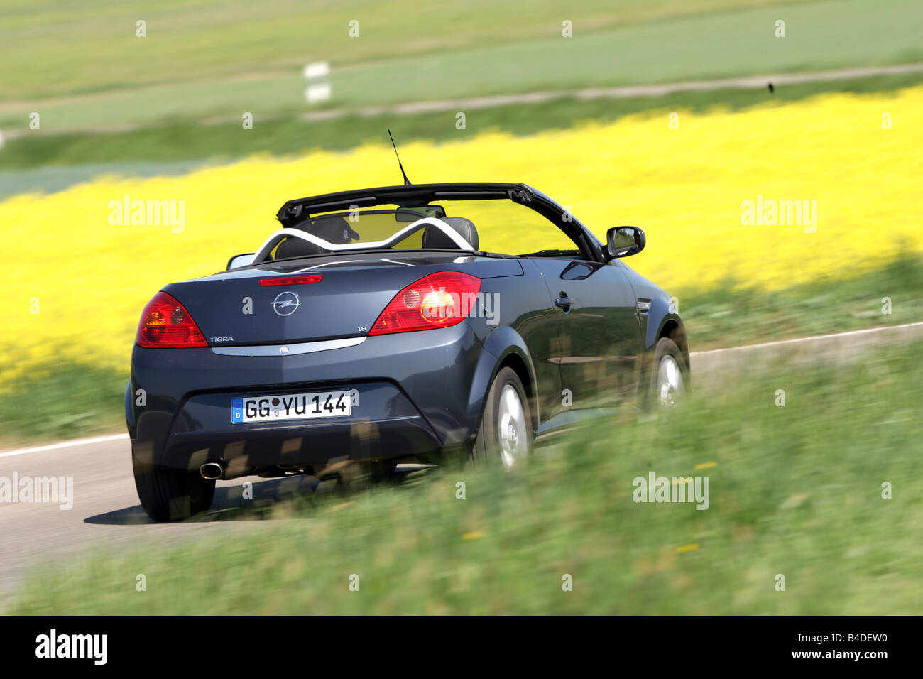 Opel Tigra 1.8 TwinTop Edition, model year 2007-, gray, driving, diagonal from the back, rear view, country road, open top Stock Photo
