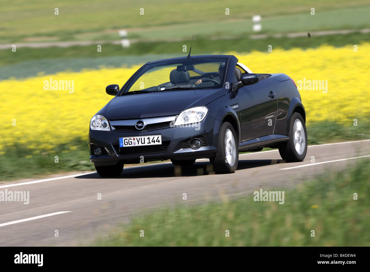 Opel Tigra 1.8 TwinTop Edition, model year 2007-, gray, driving, diagonal from the front, frontal view, country road, open top Stock Photo